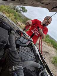 Forian attaches the jumpstart cables to the car's engine